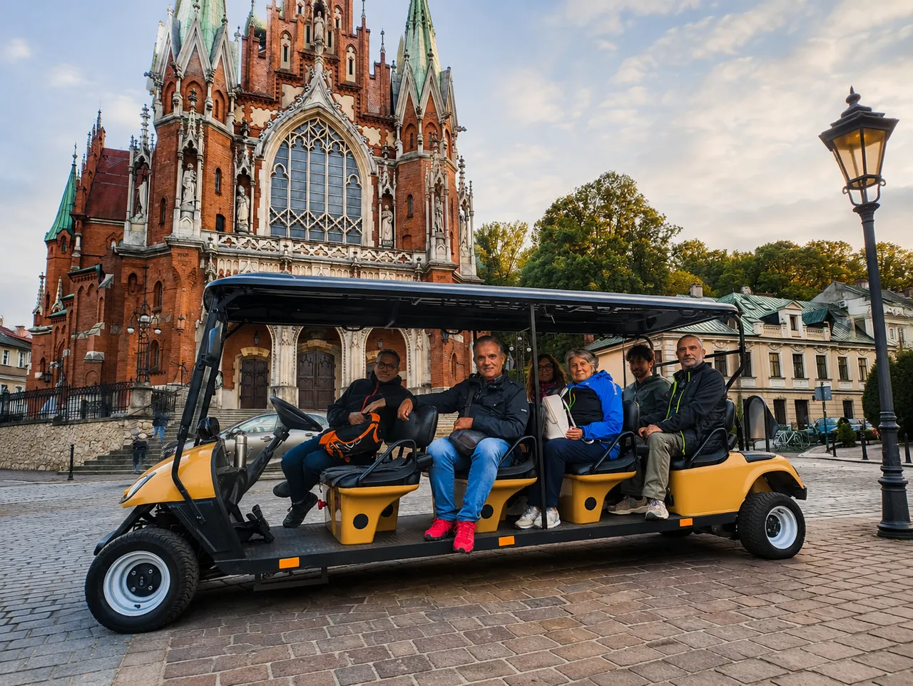 YourKrakow electric cart tour with guests in front of a Krakow church