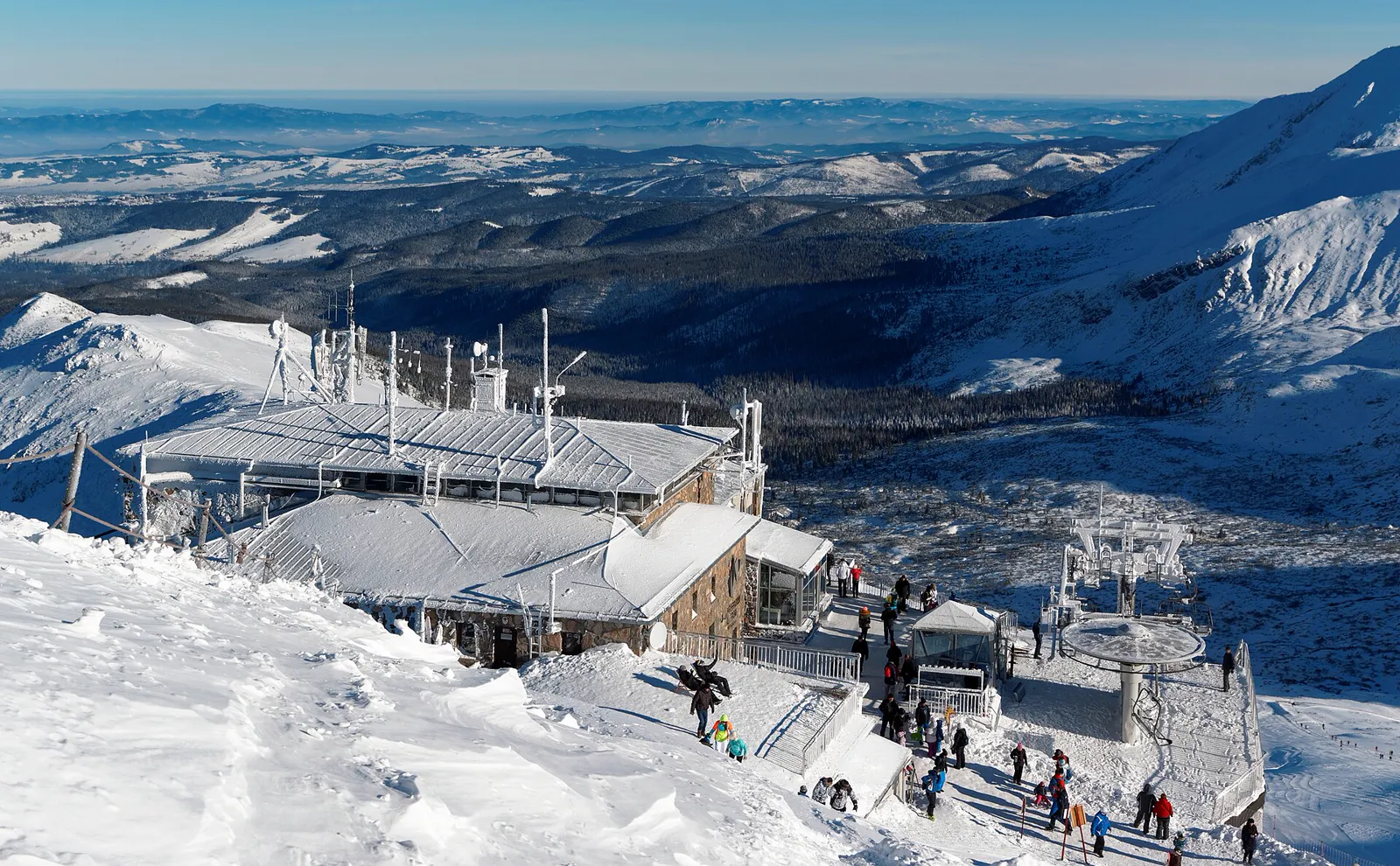 Snow-covered upper cable car station on Kasprowy Wierch above wide mountain valleys