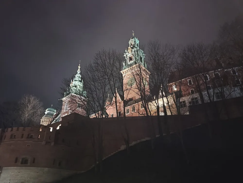 Wawel Castle and the Vistula river illuminated at night in Krakow
