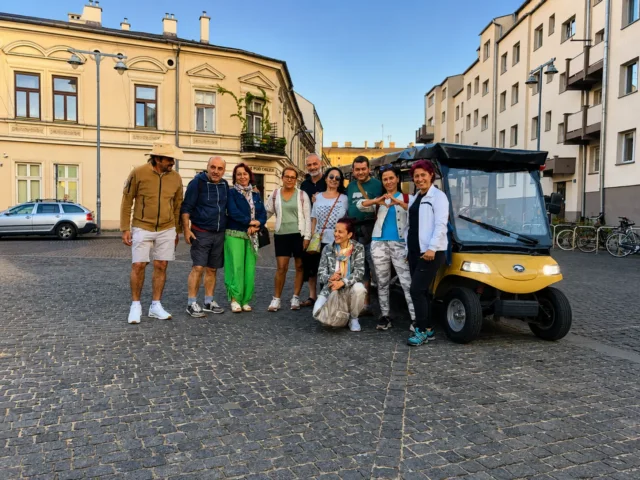Group posing by a YourKrakow electric cart in Krakow